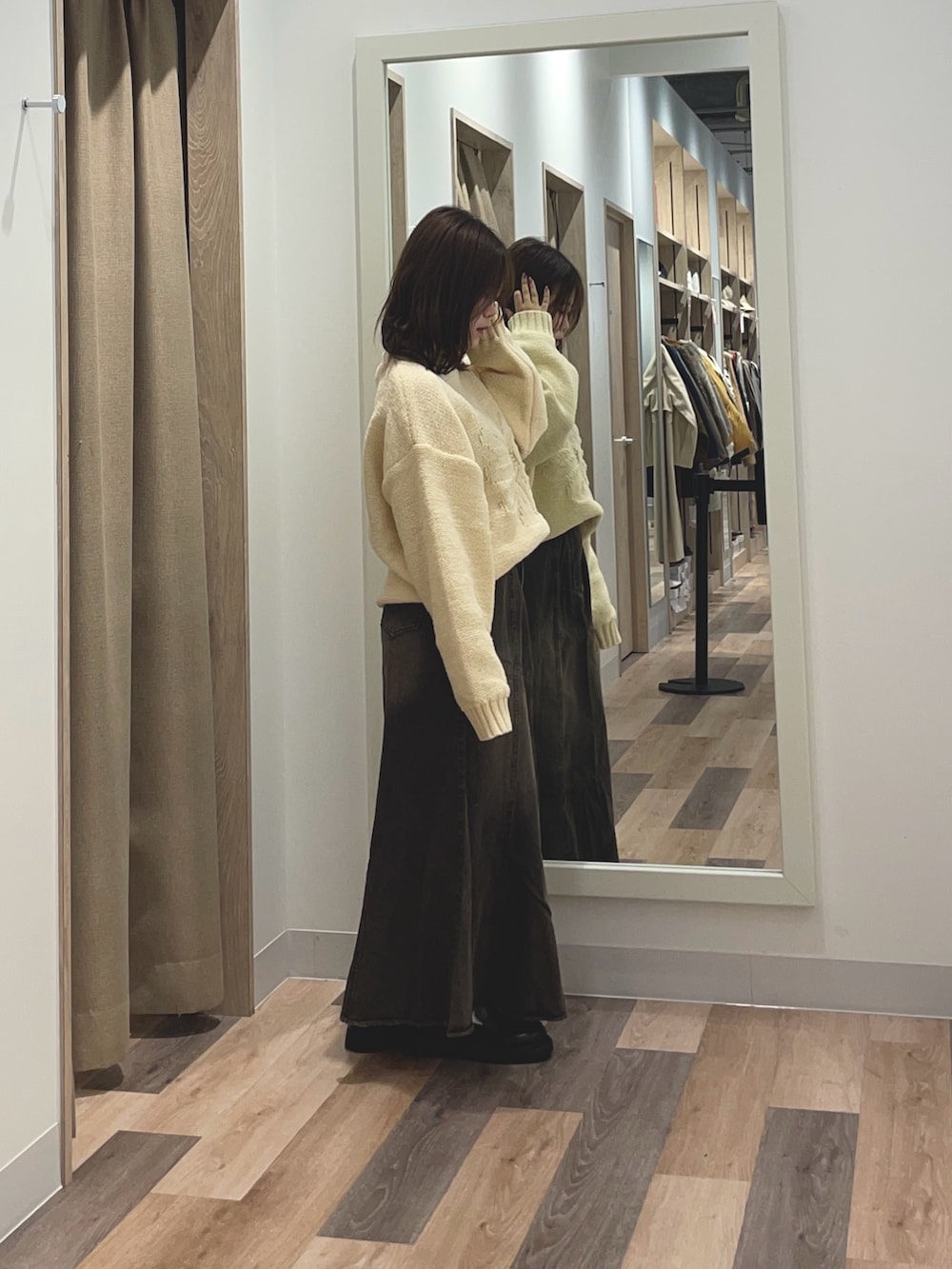 ブルー系のニット/セーター、ブルー系のスカートを着用したレディースの秋コーディネートの2枚目の写真