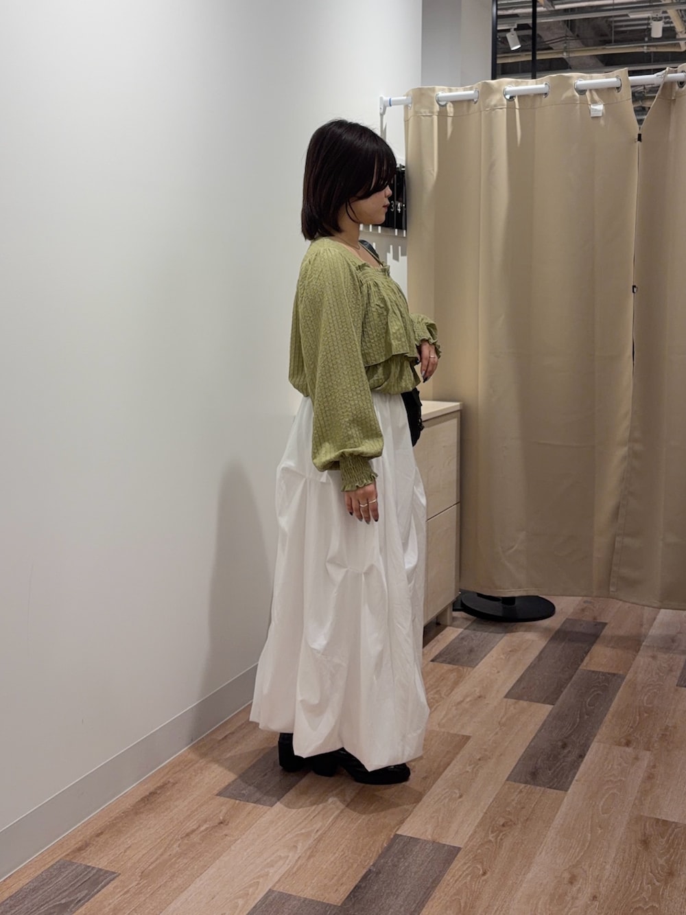 ホワイト系のスカート、ブラック系のトートバッグを着用したレディースの春コーディネートの3枚目の写真