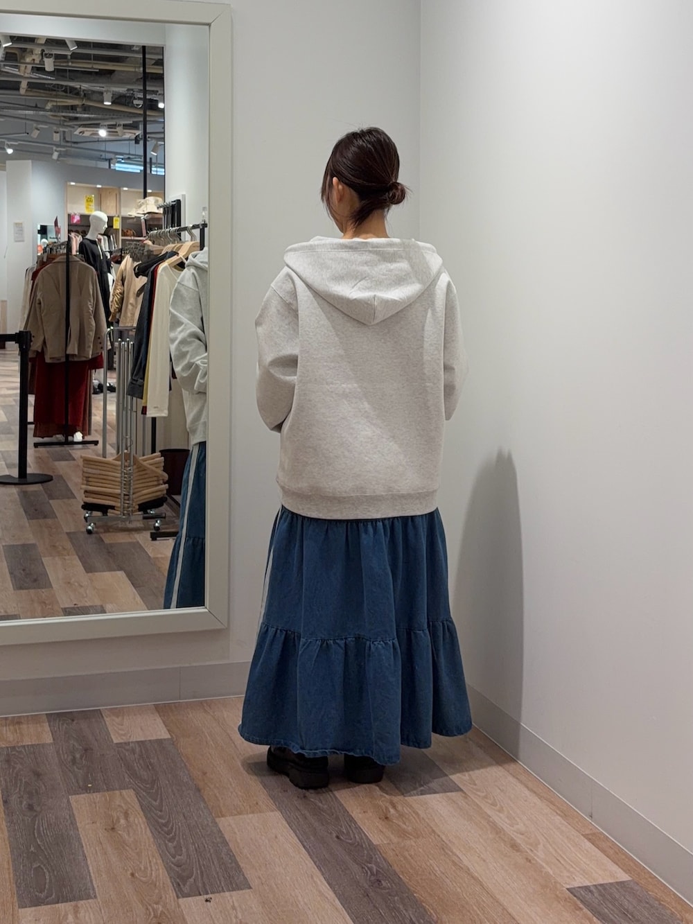 ホワイト系のパーカー、ブラック系のスカートを着用したレディースの冬コーディネートの3枚目の写真