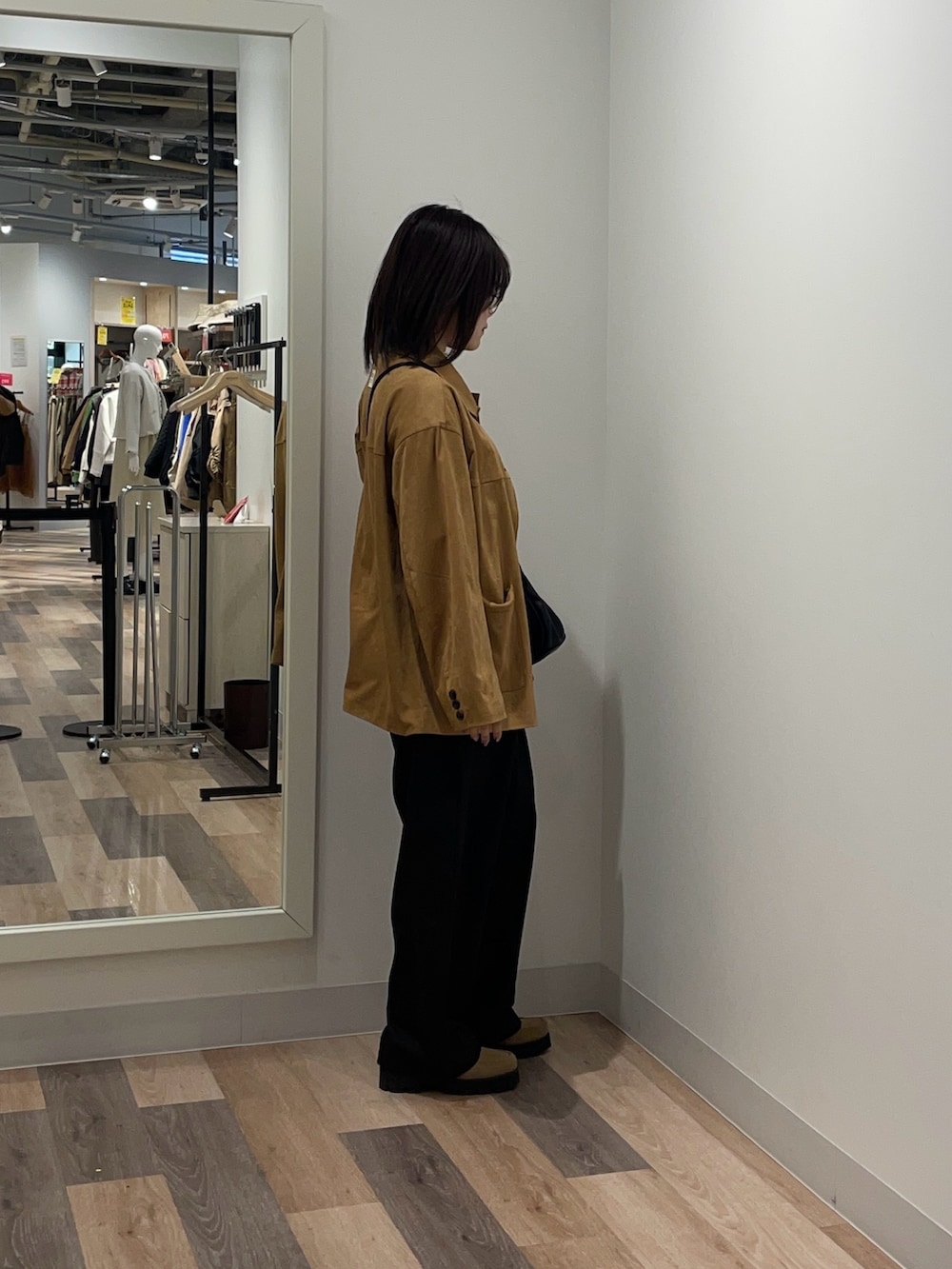 グレー系のスラックス、イエロー系のブルゾン、ホワイト系のニット/セーターを着用したレディースの冬コーディネートの2枚目の写真