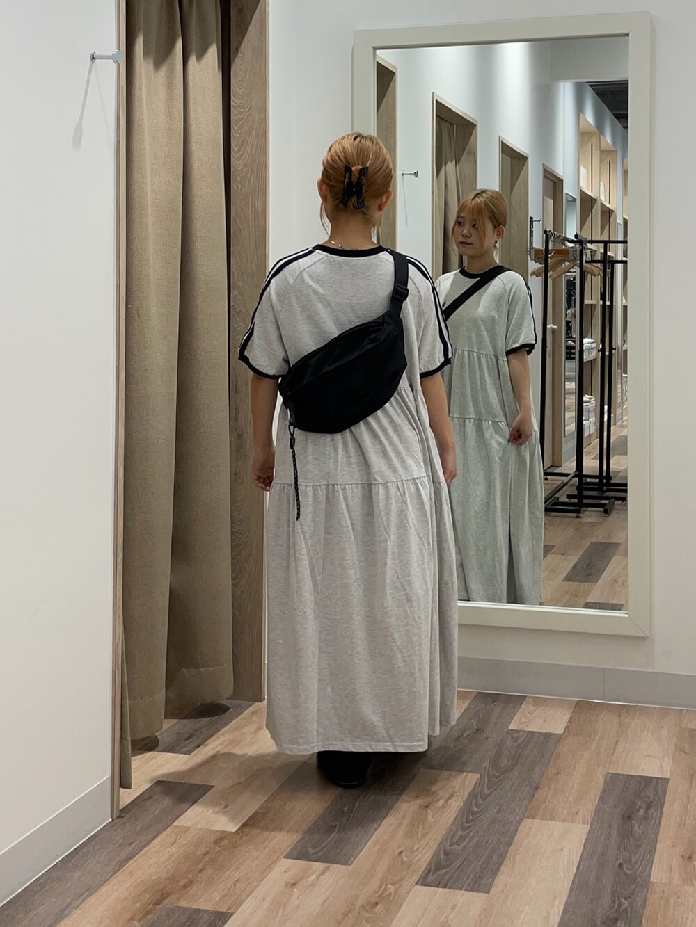 オレンジ系のワンピース、ブラック系のデニムパンツを着用したレディースの夏コーディネートの3枚目の写真