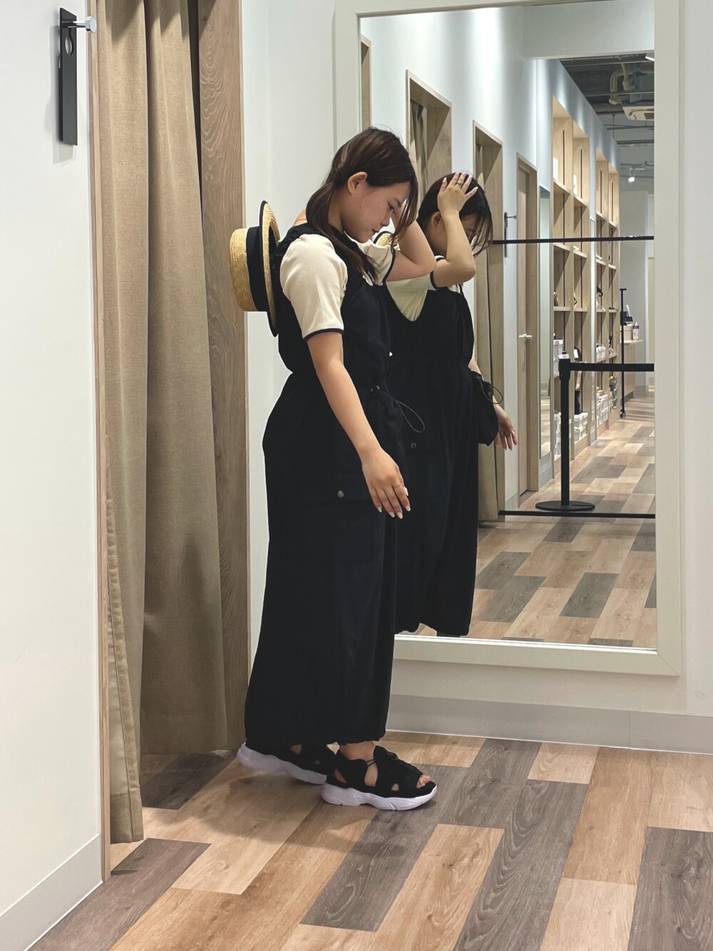 ブラック系のワンピース、ホワイト系のTシャツ/カットソー、ブラック系のサンダルを着用したレディースの夏コーディネートの2枚目の写真