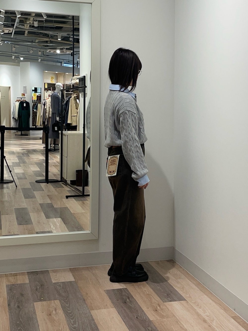 グレー系のニット/セーター、ブラウン系のデニムパンツを着用したレディースの冬コーディネートの2枚目の写真