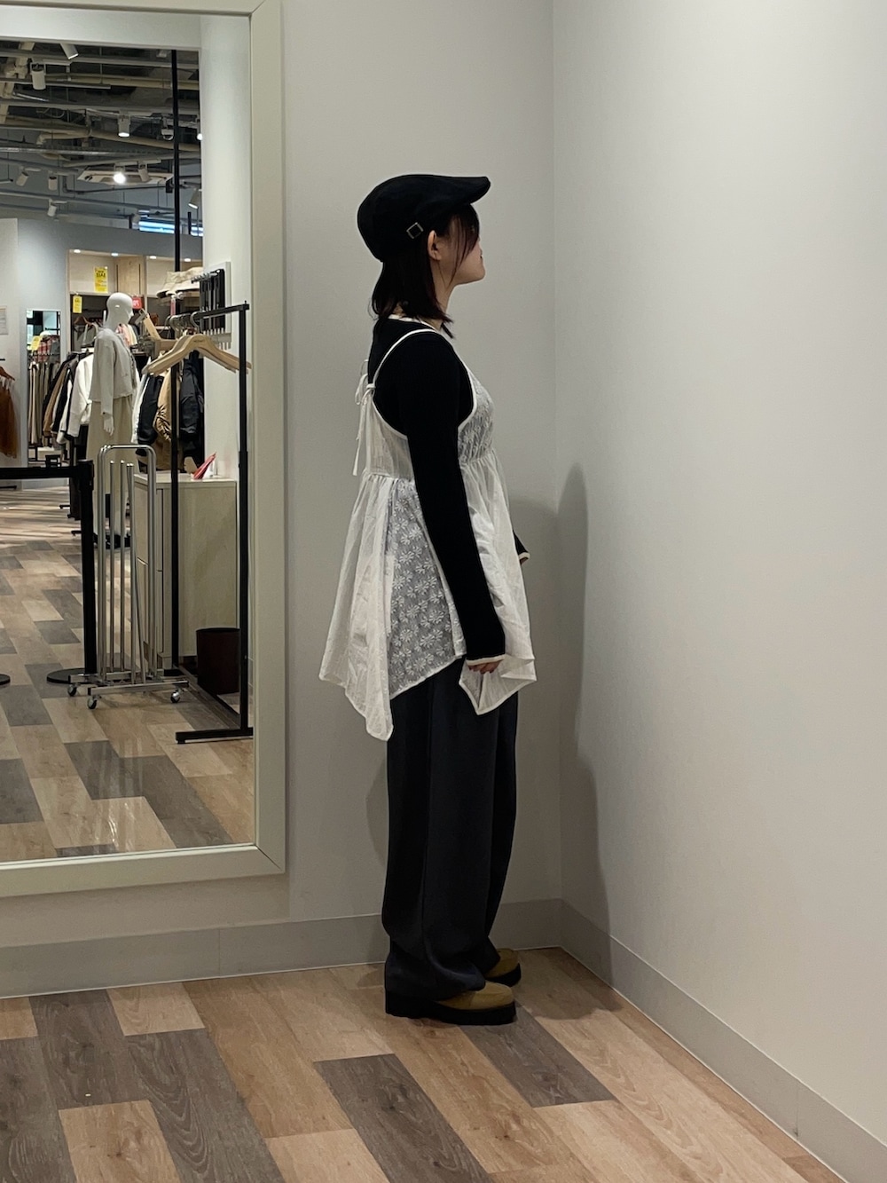 ブラック系のニット/セーター、ホワイト系のシャツ/ブラウス、グレー系のスラックスを着用したレディースの冬コーディネートの2枚目の写真