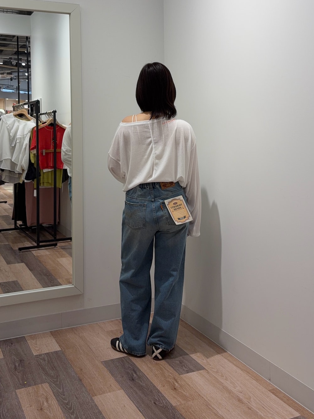 ホワイト系のキャミソール、ホワイト系のTシャツ/カットソー、ブルー系のデニムパンツを着用したレディースの春コーディネートの3枚目の写真