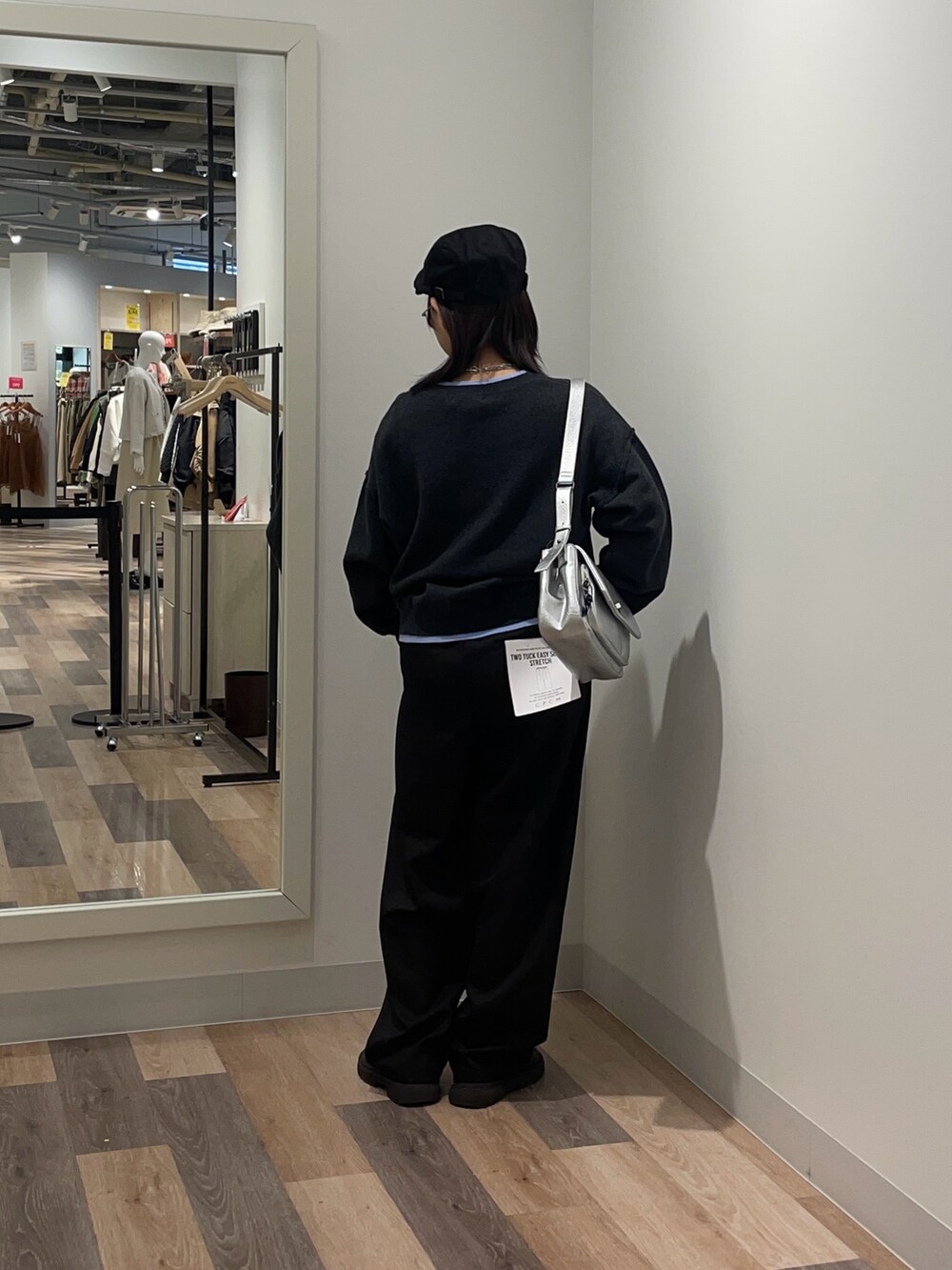 グレー系のニット/セーター、グレー系のスラックス、シルバー系のトートバッグを着用したレディースの冬コーディネートの3枚目の写真