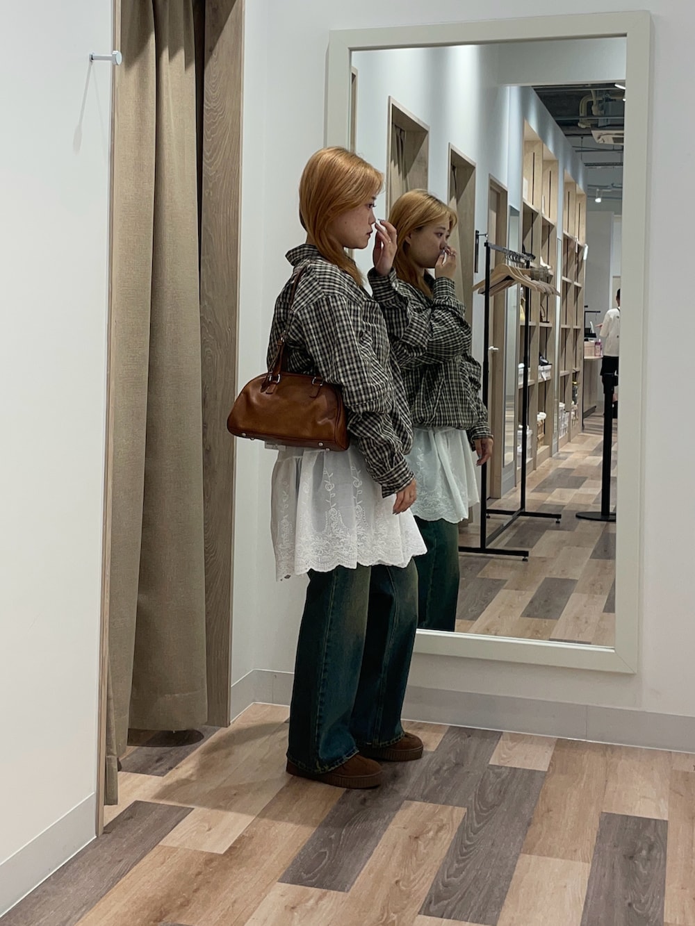 ブラック系のシャツ/ブラウス、ブルー系のデニムパンツ、ブラウン系のボストンバッグを着用したレディースの夏コーディネートの2枚目の写真