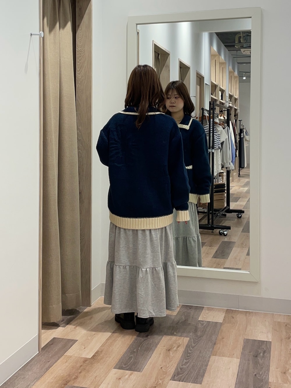 ブルー系のカーディガン/ボレロ、グレー系のスカートを着用したレディースの秋コーディネートの3枚目の写真