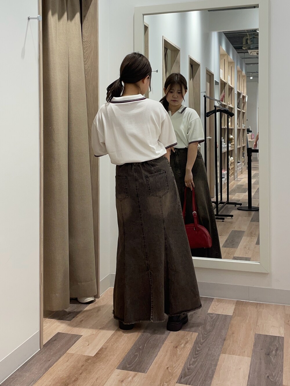 ブルー系のニット/セーター、ブルー系のスカート、ブラウン系のボストンバッグを着用したレディースの秋コーディネートの3枚目の写真