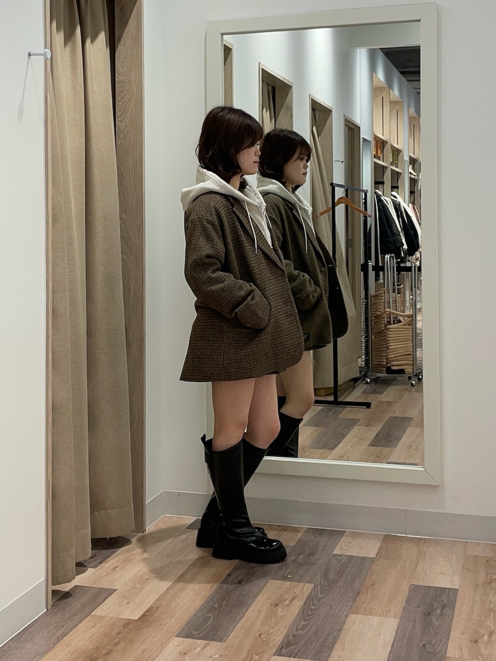 グレー系のパーカー、ブラウン系のテーラードジャケットを着用したレディースの冬コーディネートの2枚目の写真