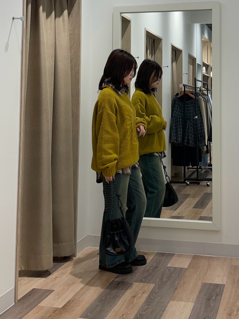 イエロー系のニット/セーター、ブルー系のデニムパンツを着用したレディースの秋コーディネートの2枚目の写真