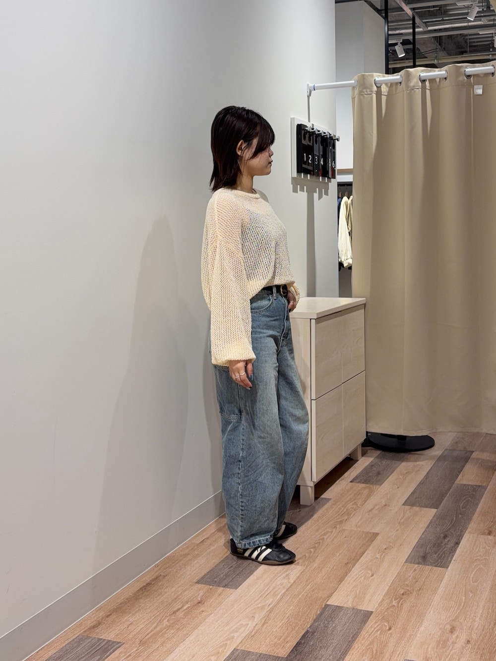 ブルー系のキャミソール、ブルー系のデニムパンツ、ホワイト系のニット/セーターを着用したレディースの春コーディネートの2枚目の写真