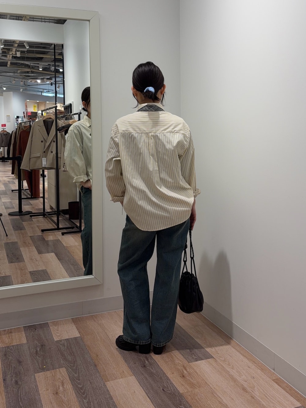 イエロー系のシャツ/ブラウス、ブルー系のデニムパンツ、ブラック系のショルダーバッグを着用したレディースの春コーディネートの3枚目の写真