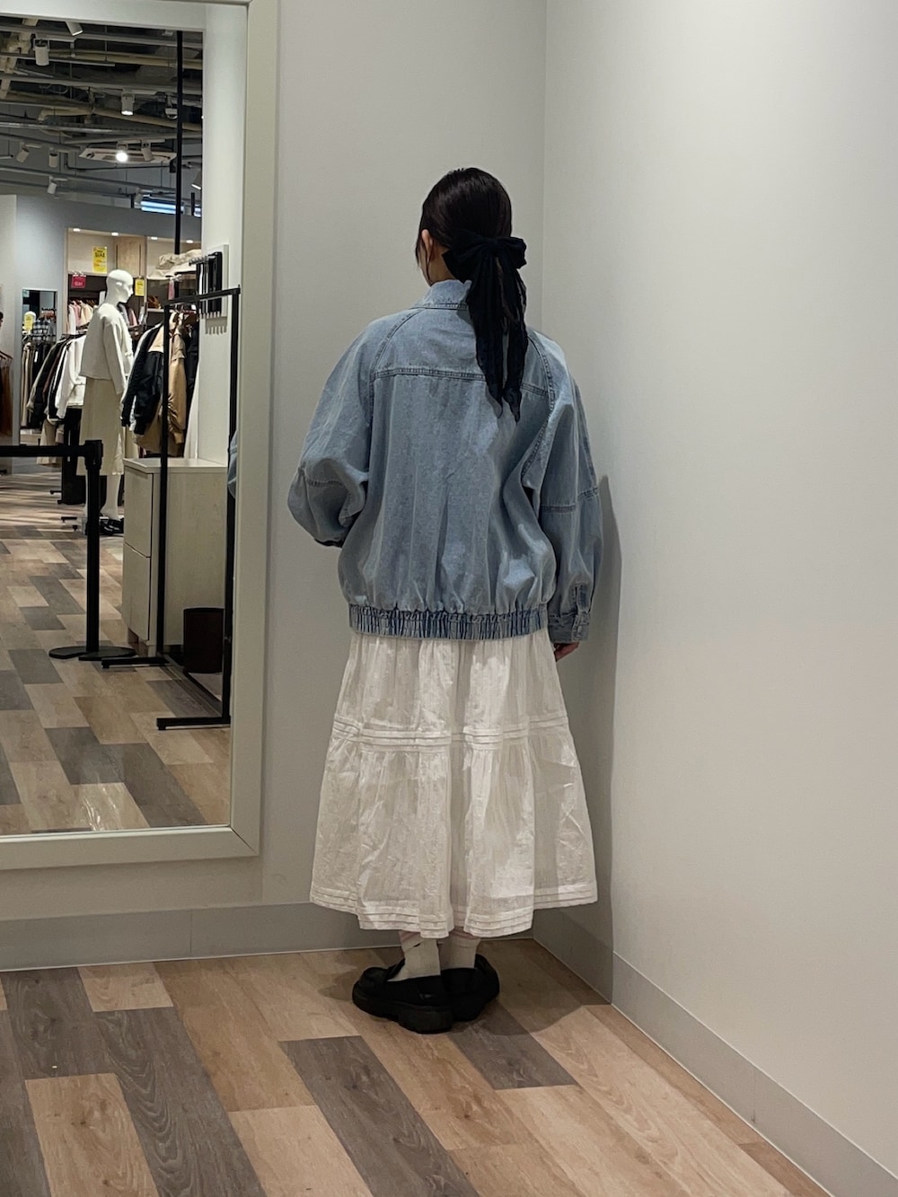 ブルー系のブルゾン、ホワイト系のスカートを着用したレディースの冬コーディネートの3枚目の写真