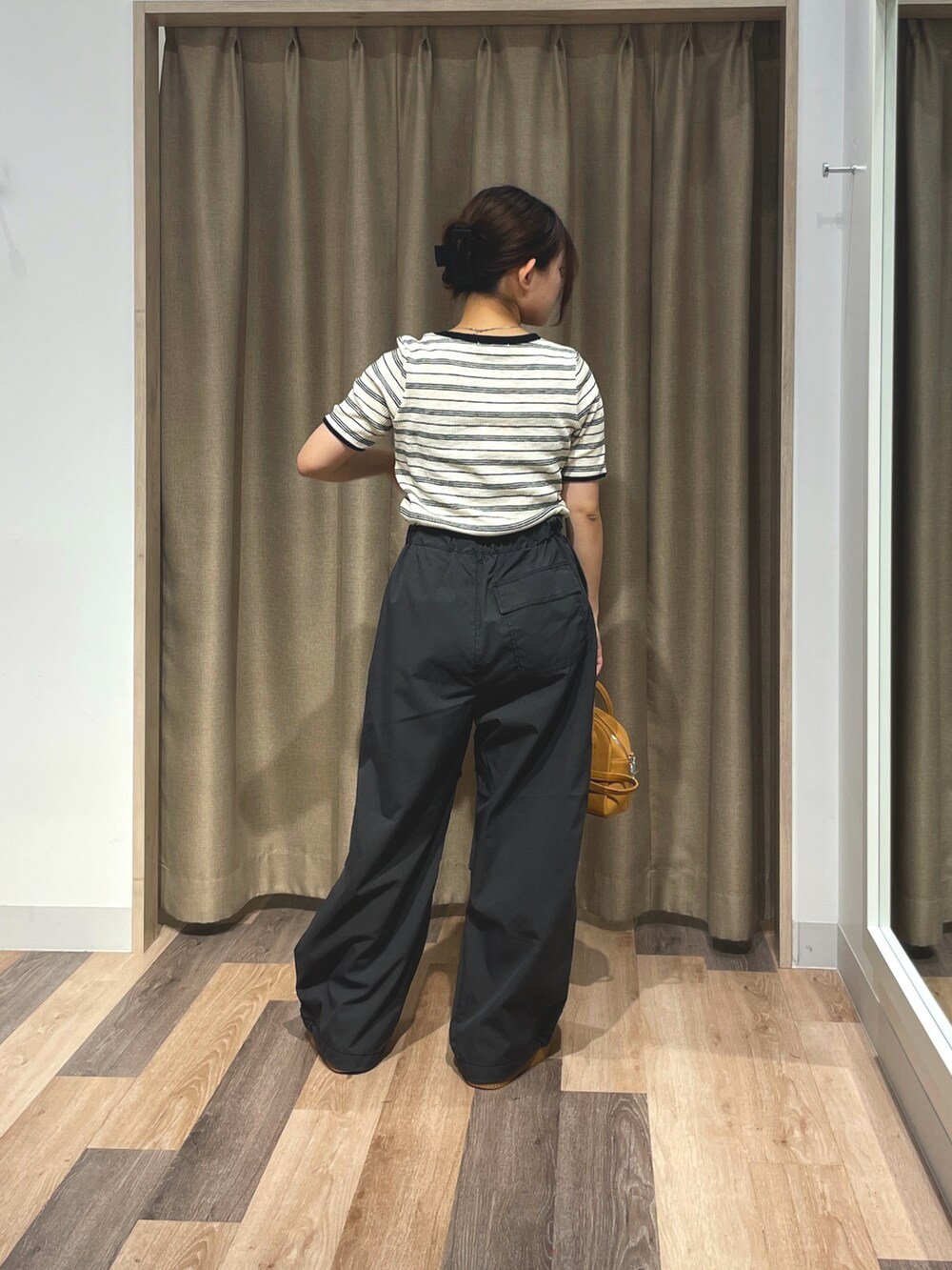 ホワイト系のTシャツ/カットソー、ブラック系のその他パンツ、イエロー系のボストンバッグを着用したレディースの夏コーディネートの3枚目の写真