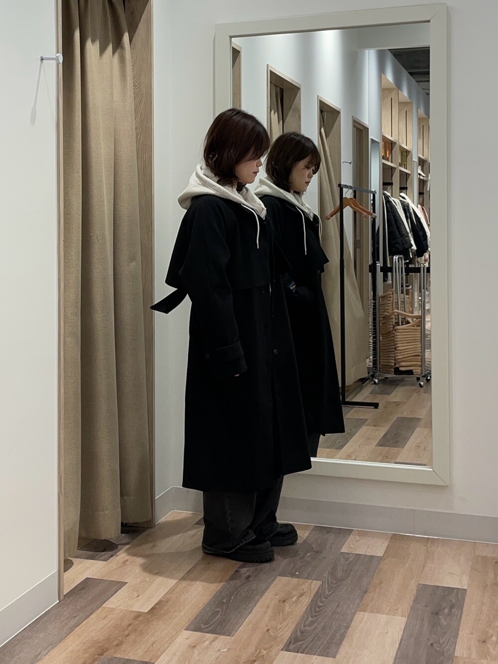 グレー系のパーカー、ブラック系のデニムパンツ、グレー系のその他アウターを着用したレディースの冬コーディネートの2枚目の写真