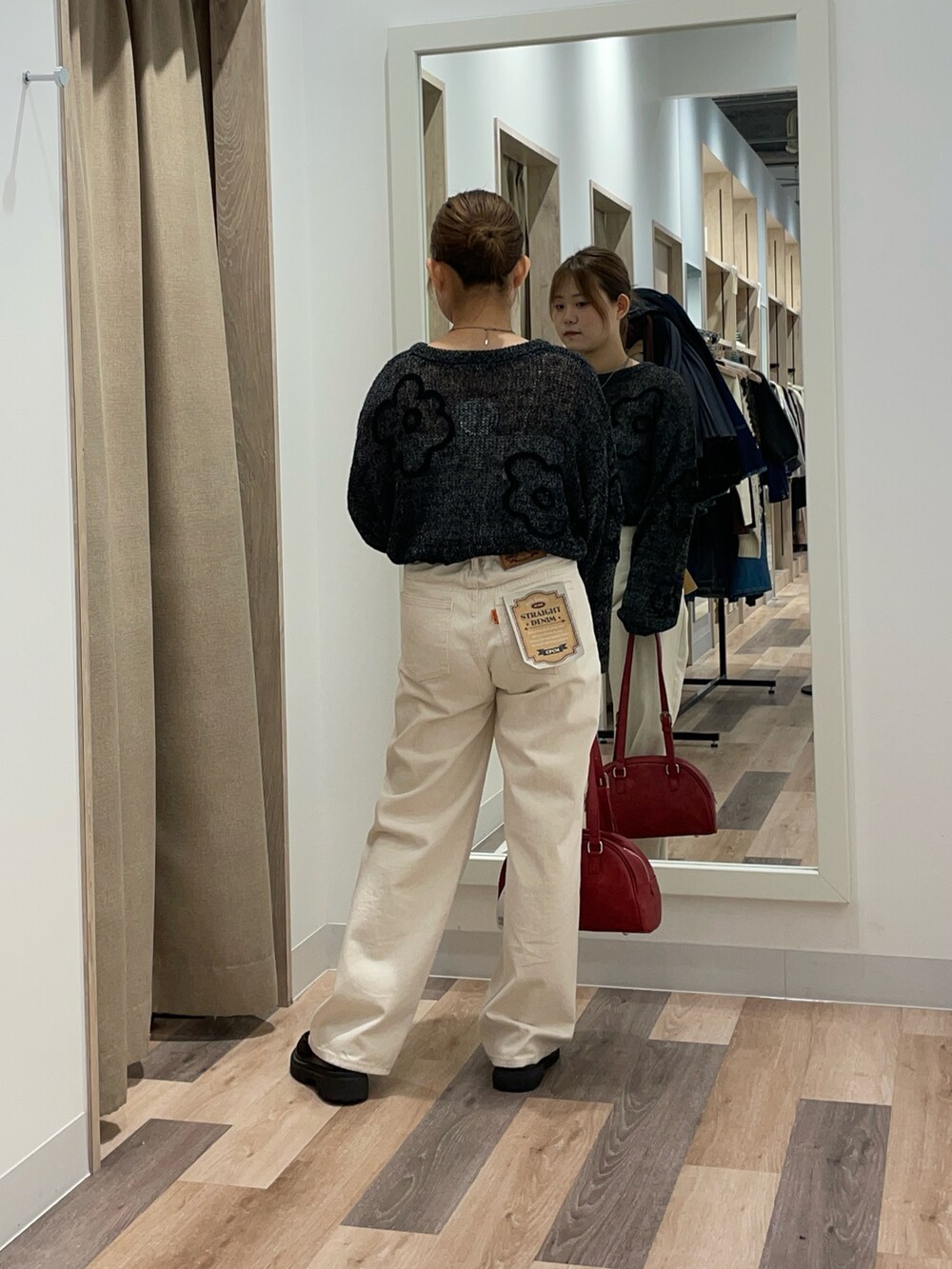 ブラック系のニット/セーター、ブラック系のデニムパンツ、ブラウン系のボストンバッグを着用したレディースの秋コーディネートの3枚目の写真