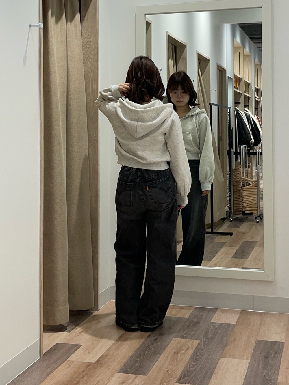 グレー系のパーカー、ブラック系のデニムパンツを着用したレディースの冬コーディネートの3枚目の写真