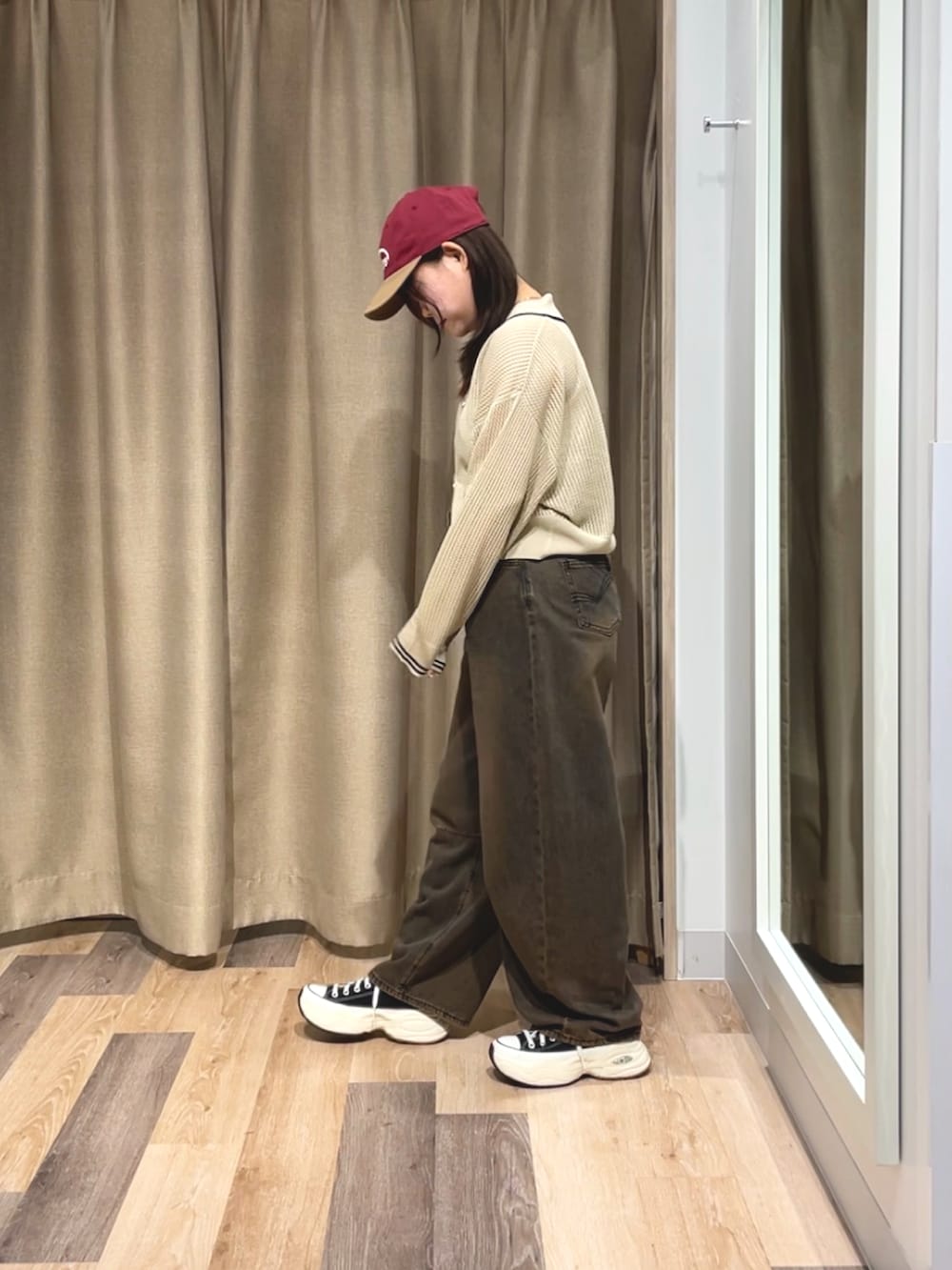 ホワイト系のカーディガン/ボレロ、ブラウン系のデニムパンツ、レッド系のキャップを着用したレディースの夏コーディネートの2枚目の写真