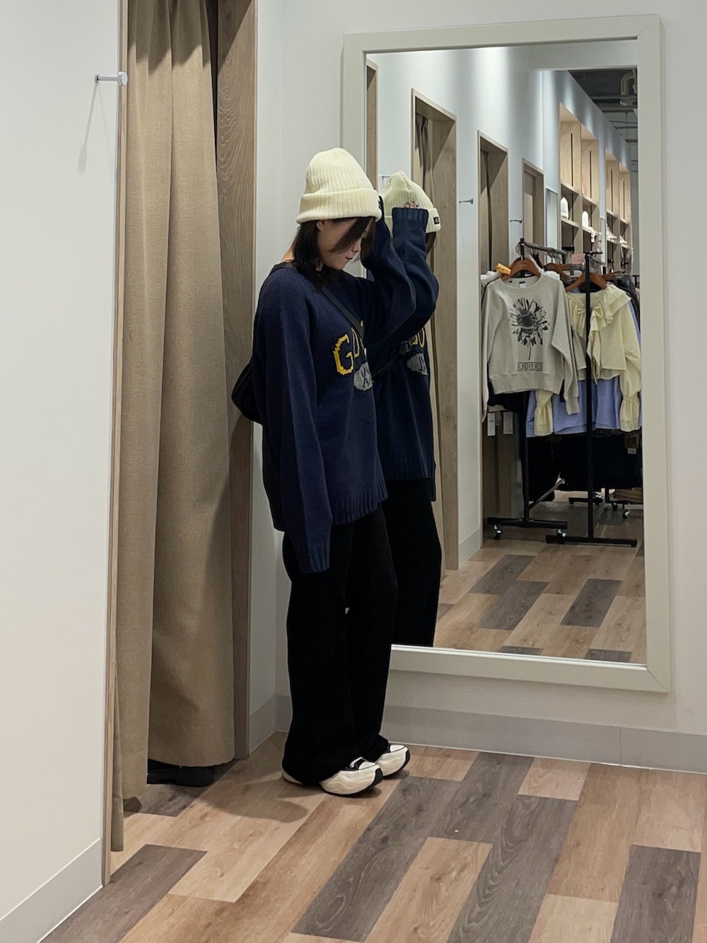 ブルー系のニット/セーター、ブラック系のその他パンツ、ブラック系のトートバッグを着用したレディースの秋コーディネートの2枚目の写真