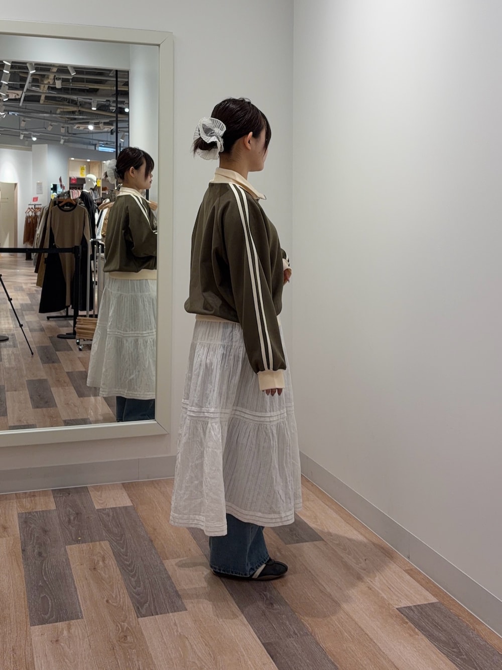 ホワイト系のスカート、ブルー系のデニムパンツ、グリーン系のブルゾンを着用したレディースの冬コーディネートの2枚目の写真