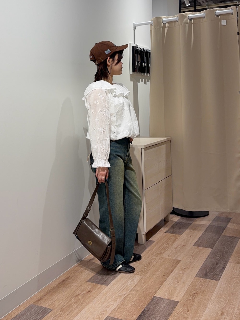 ホワイト系のシャツ/ブラウス、ブルー系のデニムパンツ、ブラウン系のトートバッグを着用したレディースの春コーディネートの2枚目の写真