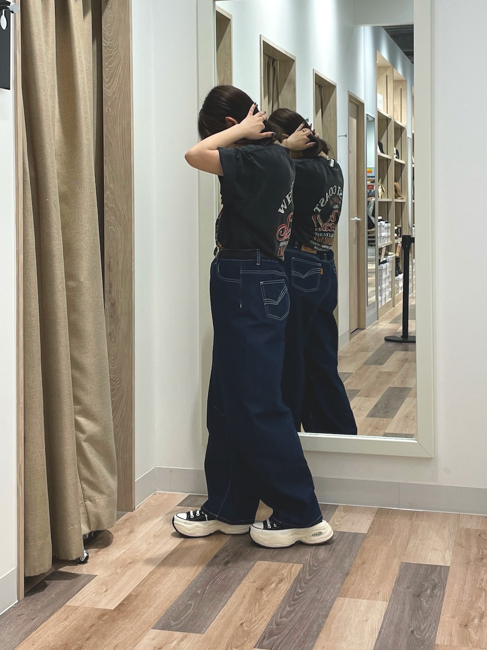 ブルー系のデニムパンツ、ブラック系のTシャツ/カットソー、ブラック系のスニーカーを着用したレディースの夏コーディネートの2枚目の写真