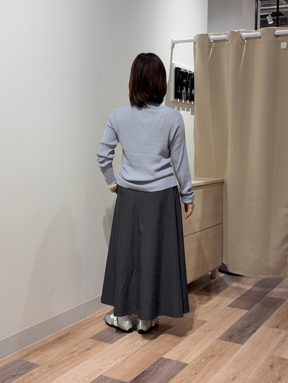 ホワイト系のキャミソール、グレー系のカーディガン/ボレロ、ベージュ系のスカートを着用したレディースの春コーディネートの3枚目の写真