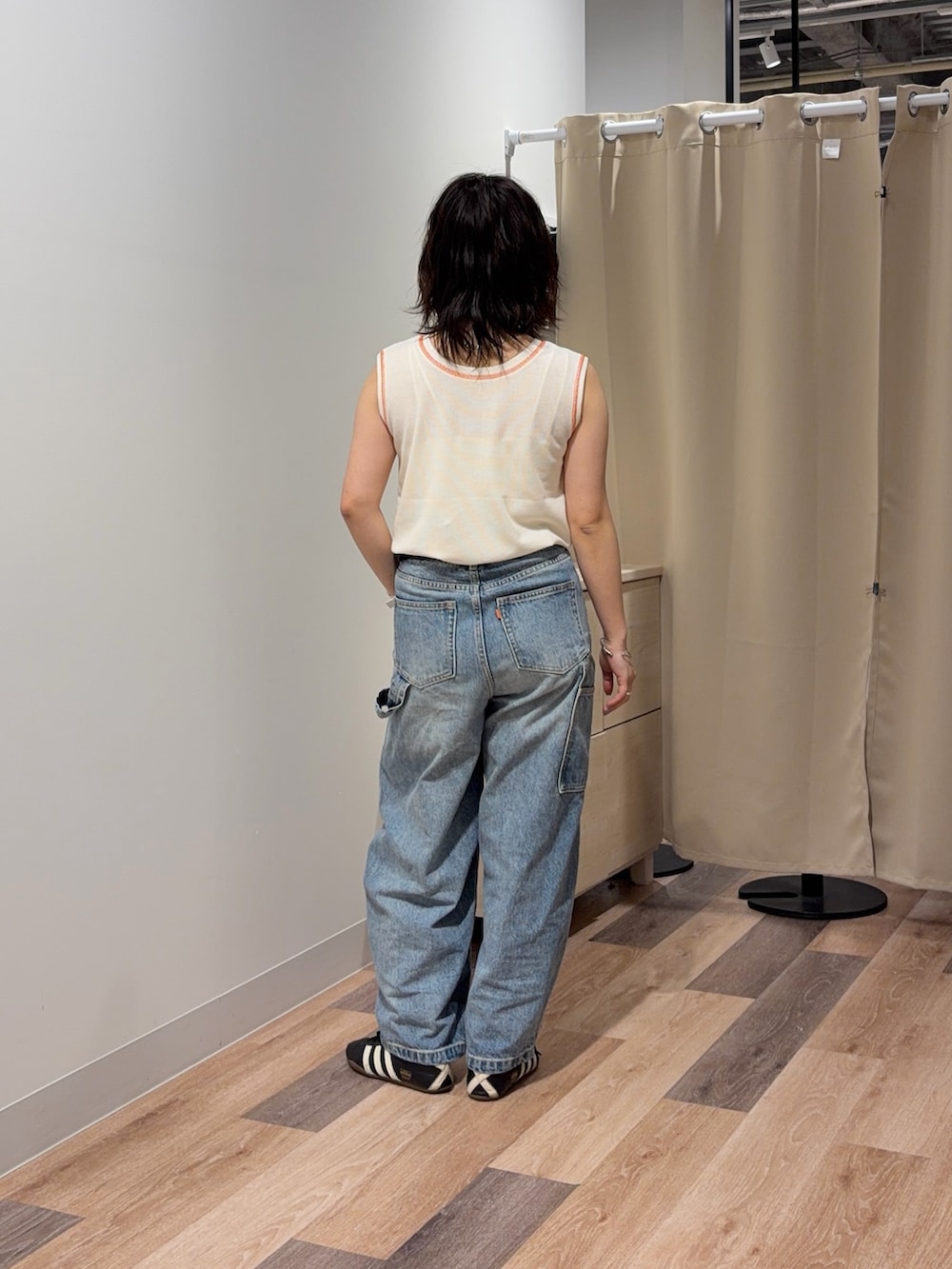 ホワイト系のキャミソール、ブルー系のデニムパンツを着用したレディースの春コーディネートの3枚目の写真