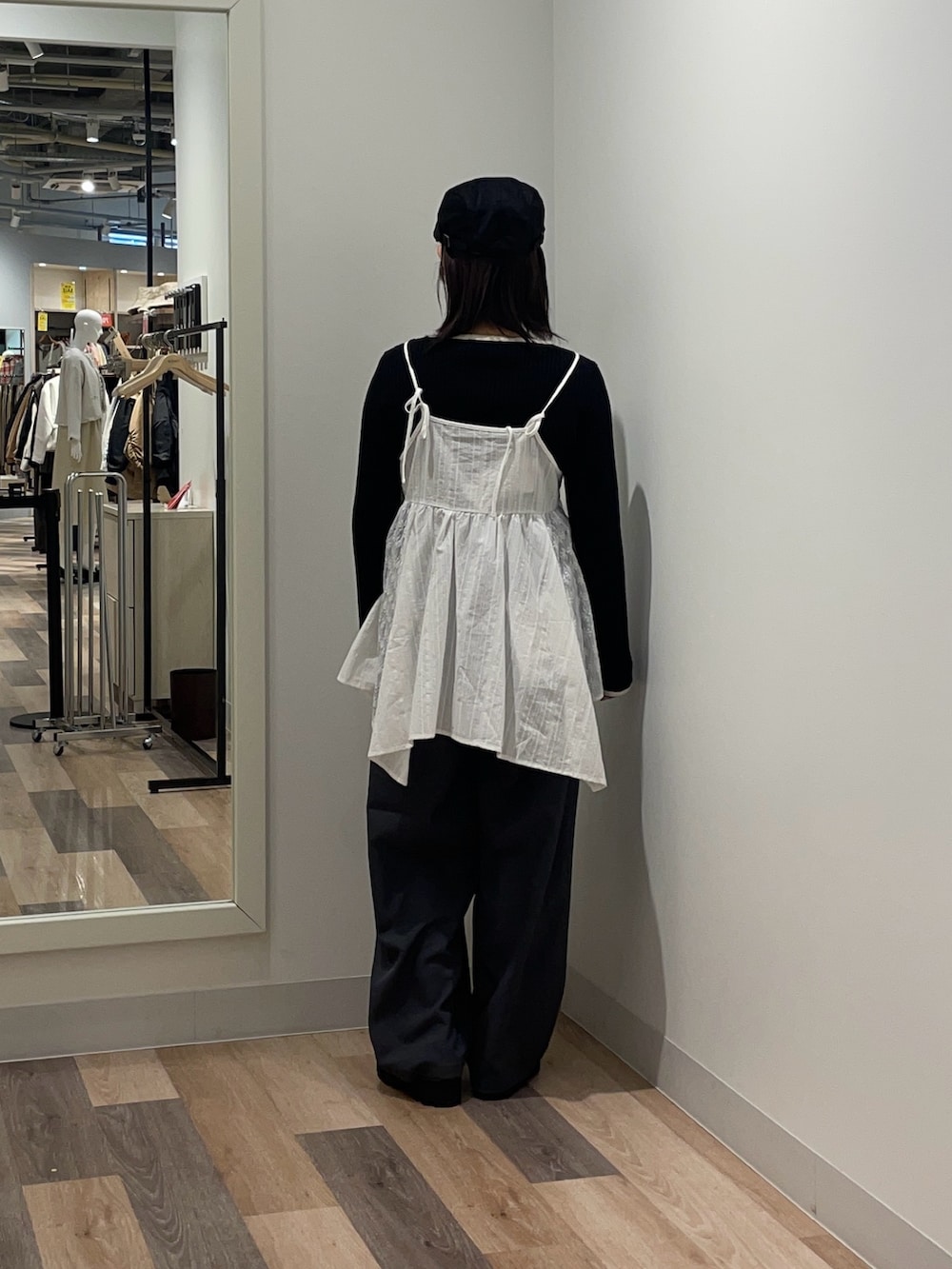 ブラック系のニット/セーター、ホワイト系のシャツ/ブラウス、グレー系のスラックスを着用したレディースの冬コーディネートの3枚目の写真