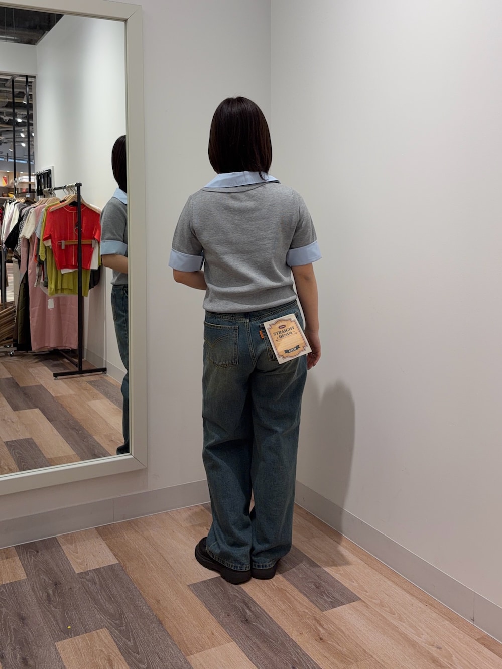 グレー系のポロシャツ、ブルー系のデニムパンツ、ブルー系のマフラーを着用したレディースの春コーディネートの3枚目の写真