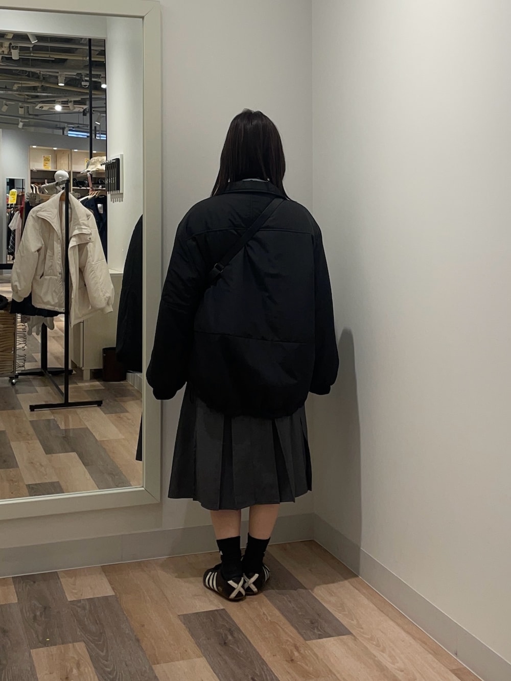 ブラック系のブルゾン、ブルー系のニット/セーター、ブラック系のトートバッグを着用したレディースの冬コーディネートの3枚目の写真