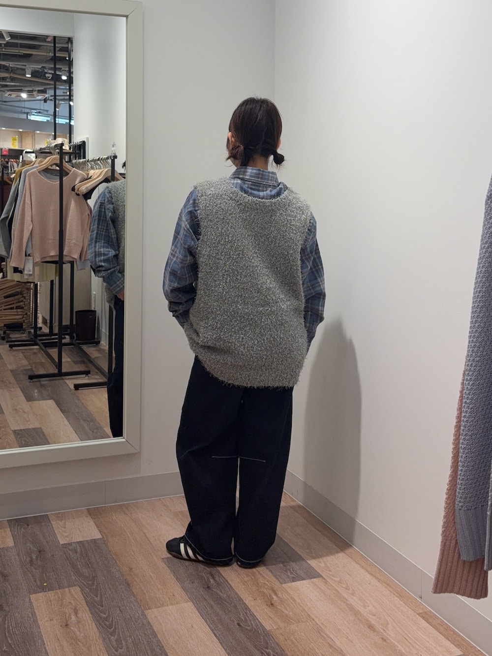 ブルー系のシャツ/ブラウス、グレー系のニット/セーター、ブルー系のデニムパンツを着用したレディースの春コーディネートの3枚目の写真