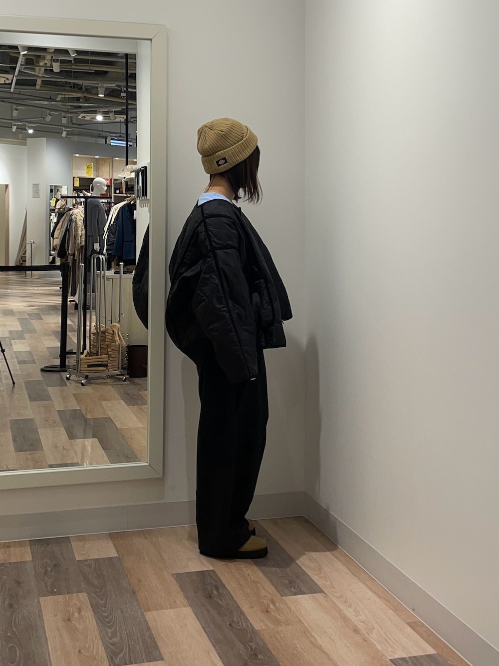 ブラック系のブルゾン、ブルー系のニット/セーター、ブラック系のスラックスを着用したレディースの冬コーディネートの2枚目の写真