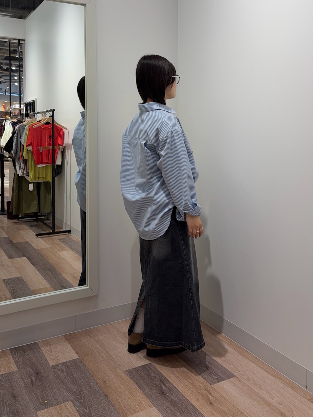 ブルー系のシャツ/ブラウス、ブラック系のスカートを着用したレディースの春コーディネートの2枚目の写真