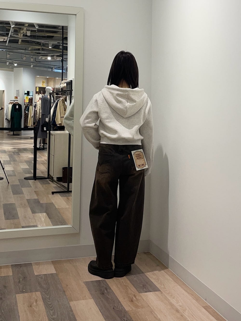 グレー系のパーカー、ブラウン系のデニムパンツを着用したレディースの冬コーディネートの3枚目の写真