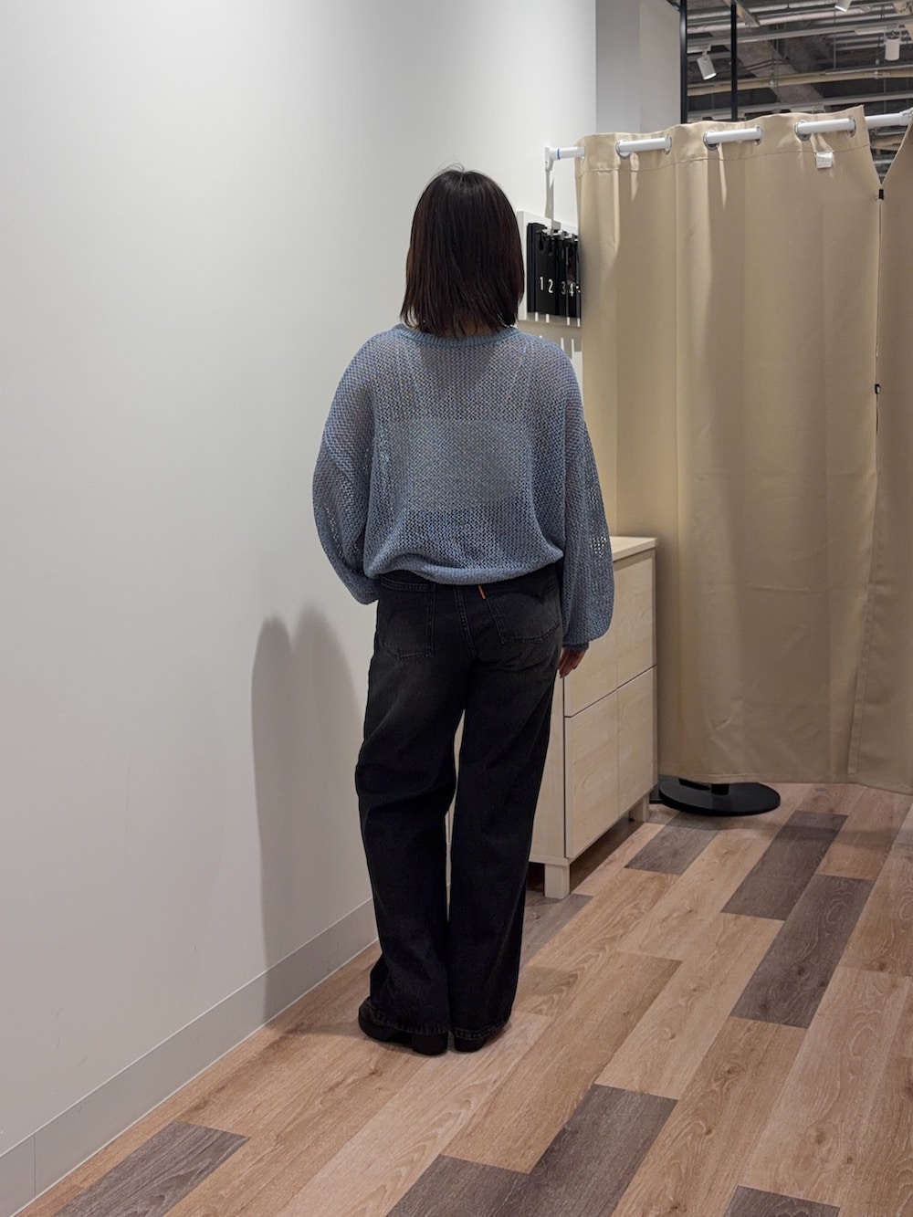 ブルー系のニット/セーター、ブラック系のデニムパンツを着用したレディースの春コーディネートの3枚目の写真