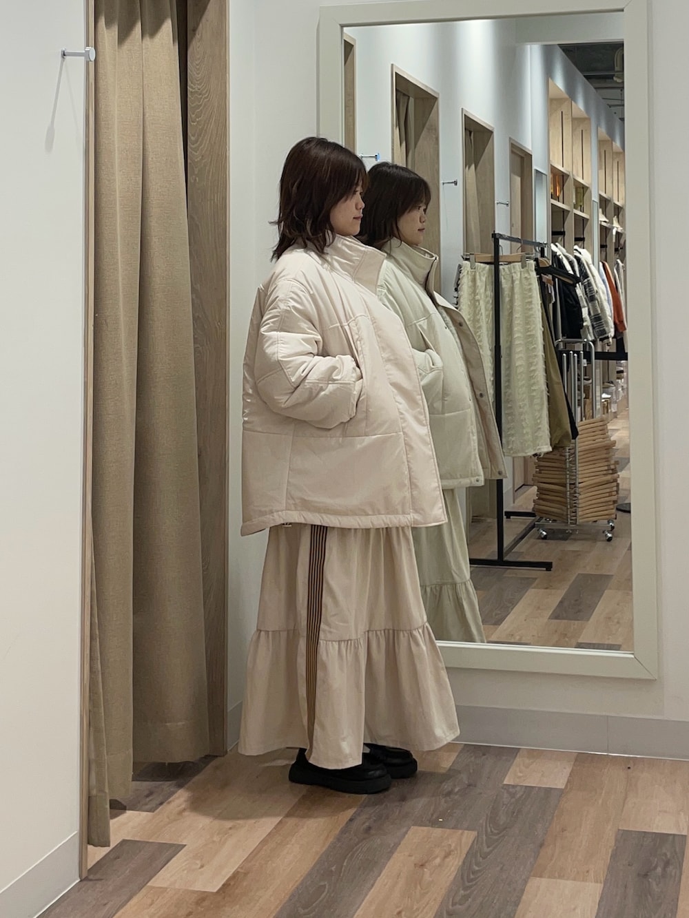 ブラック系のブルゾン、ホワイト系のスカート、ホワイト系のニット/セーターを着用したレディースの冬コーディネートの2枚目の写真