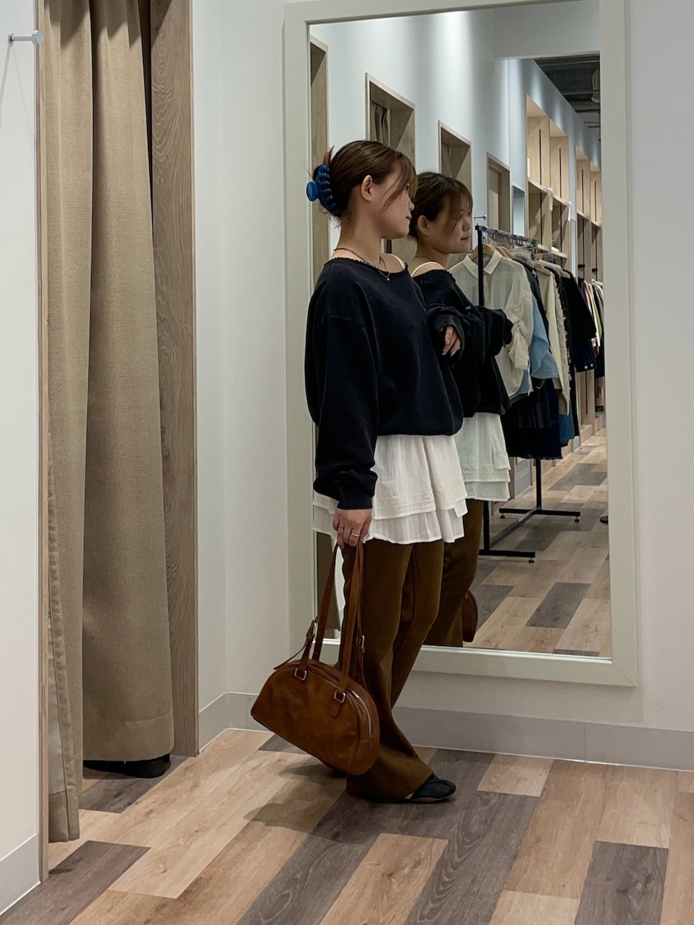 グリーン系のスウェット、ブラック系のその他パンツ、ブラウン系のボストンバッグを着用したレディースの秋コーディネートの2枚目の写真