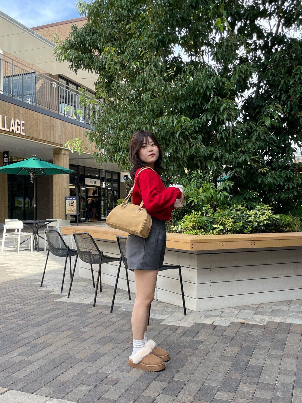 レッド系のニット/セーター、ブラウン系のボストンバッグ、イエロー系のブーツを着用したレディースの秋コーディネートの2枚目の写真