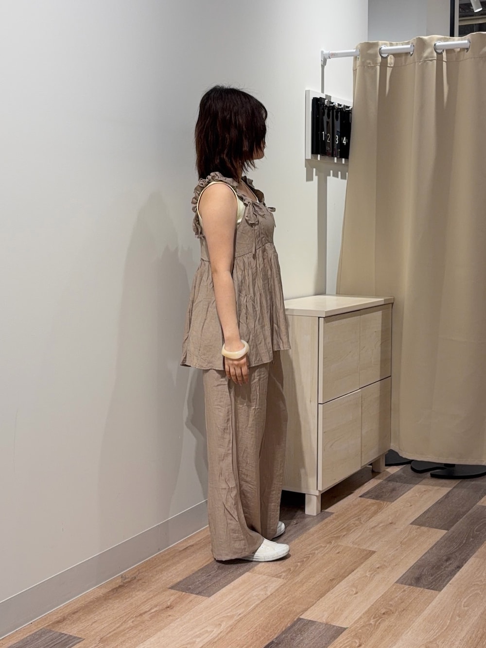 ベージュ系のワンピース、ホワイト系のキャミソールを着用したレディースの春コーディネートの2枚目の写真