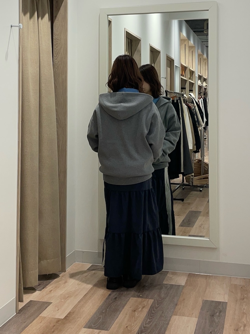 ブラック系のブルゾン、グレー系のニット/セーター、ブルー系のスカートを着用したレディースの冬コーディネートの4枚目の写真