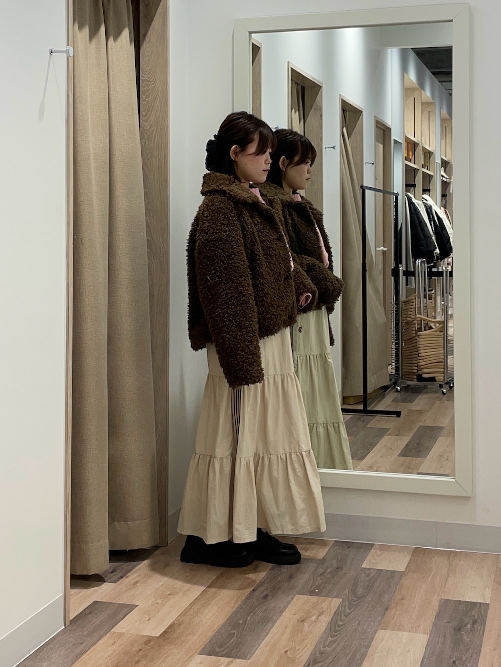 ブラウン系のブルゾン、ピンク系のニット/セーター、ホワイト系のスカートを着用したレディースの冬コーディネートの2枚目の写真