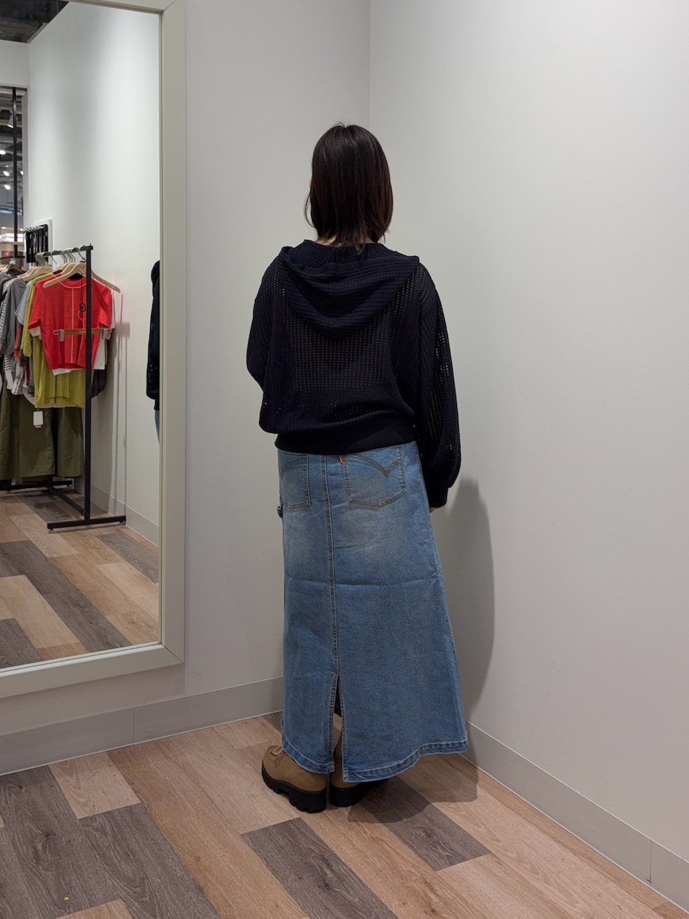 ブルー系のスカート、ブルー系のパーカー、ホワイト系のキャミソールを着用したレディースの春コーディネートの3枚目の写真