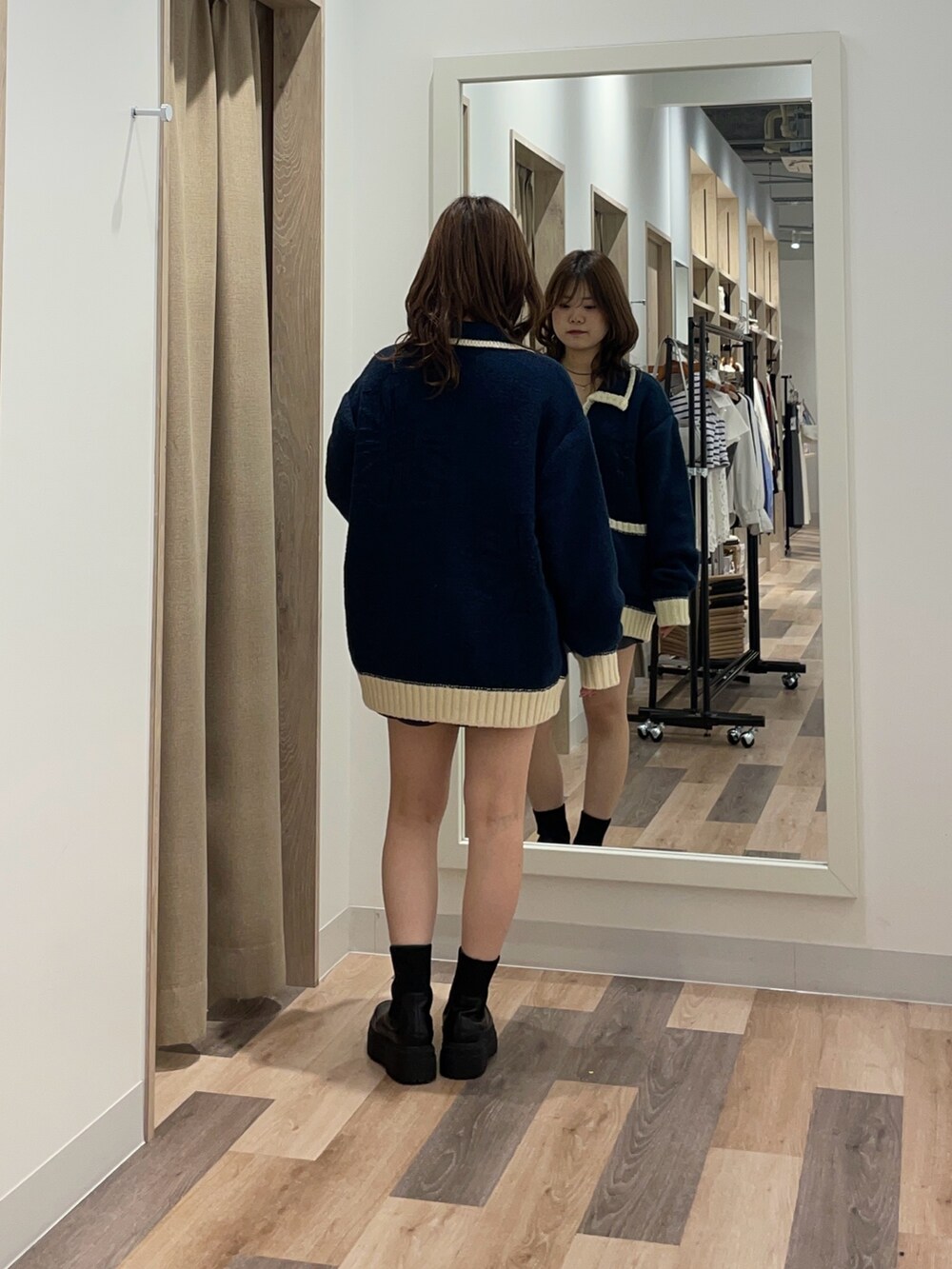 ブルー系のカーディガン/ボレロ、ブラック系のブーツを着用したレディースの秋コーディネートの3枚目の写真