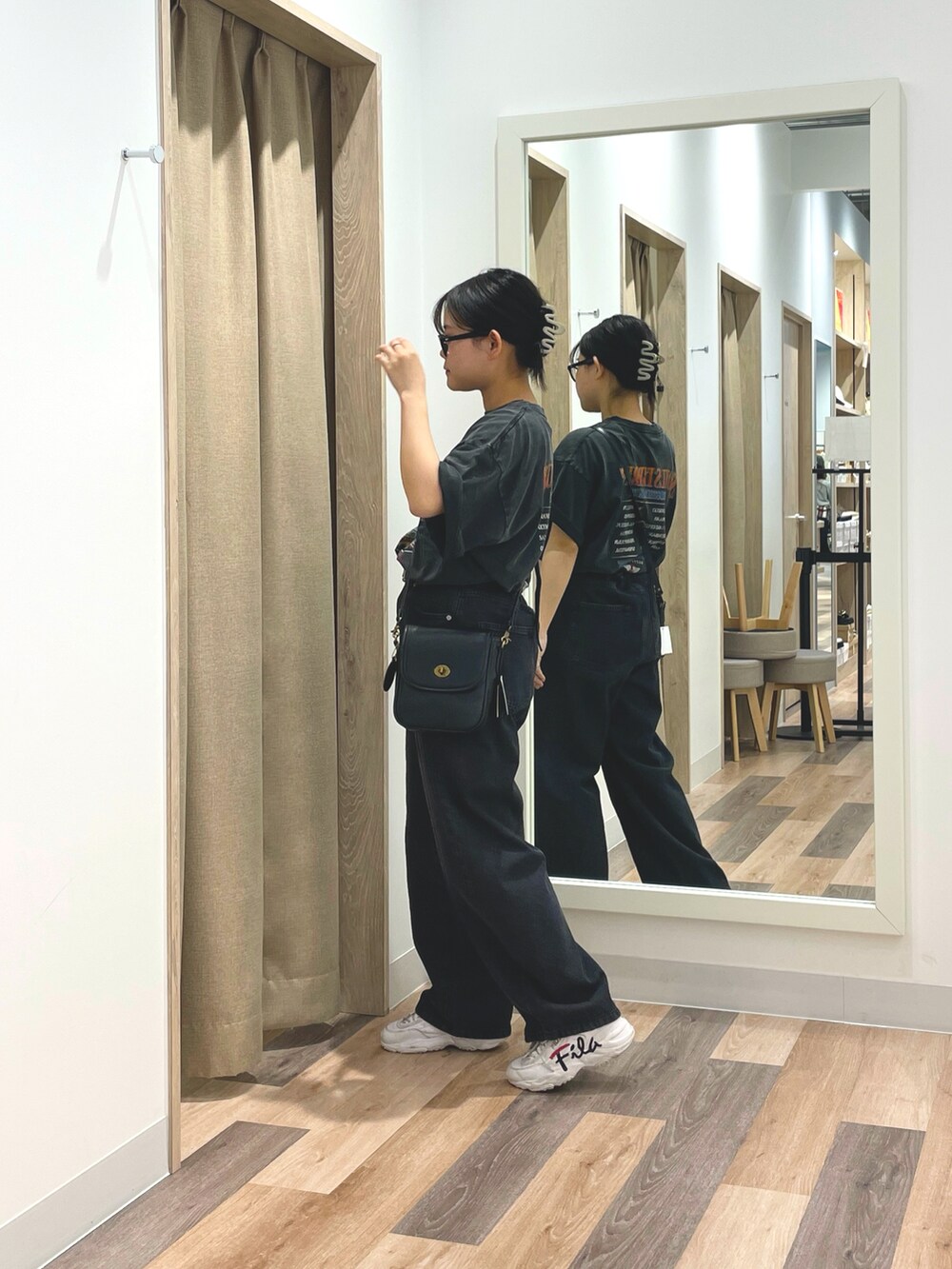 ブラック系のTシャツ/カットソー、ブラック系のデニムパンツ、ブラック系のショルダーバッグを着用したレディースの夏コーディネートの2枚目の写真