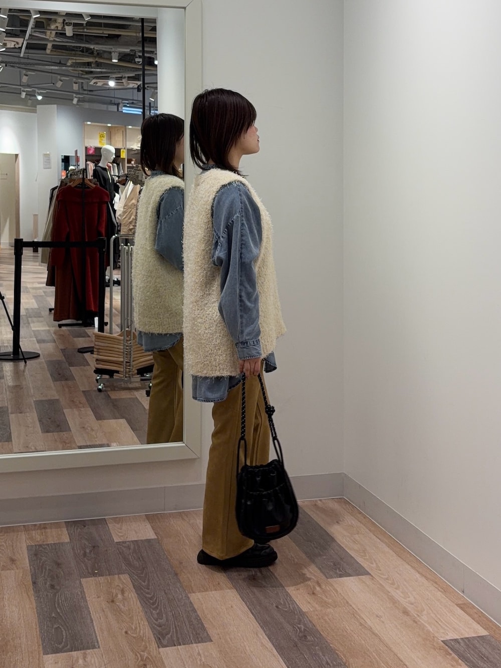 ホワイト系のニット/セーター、ホワイト系のその他パンツ、ブラック系のショルダーバッグを着用したレディースの冬コーディネートの2枚目の写真