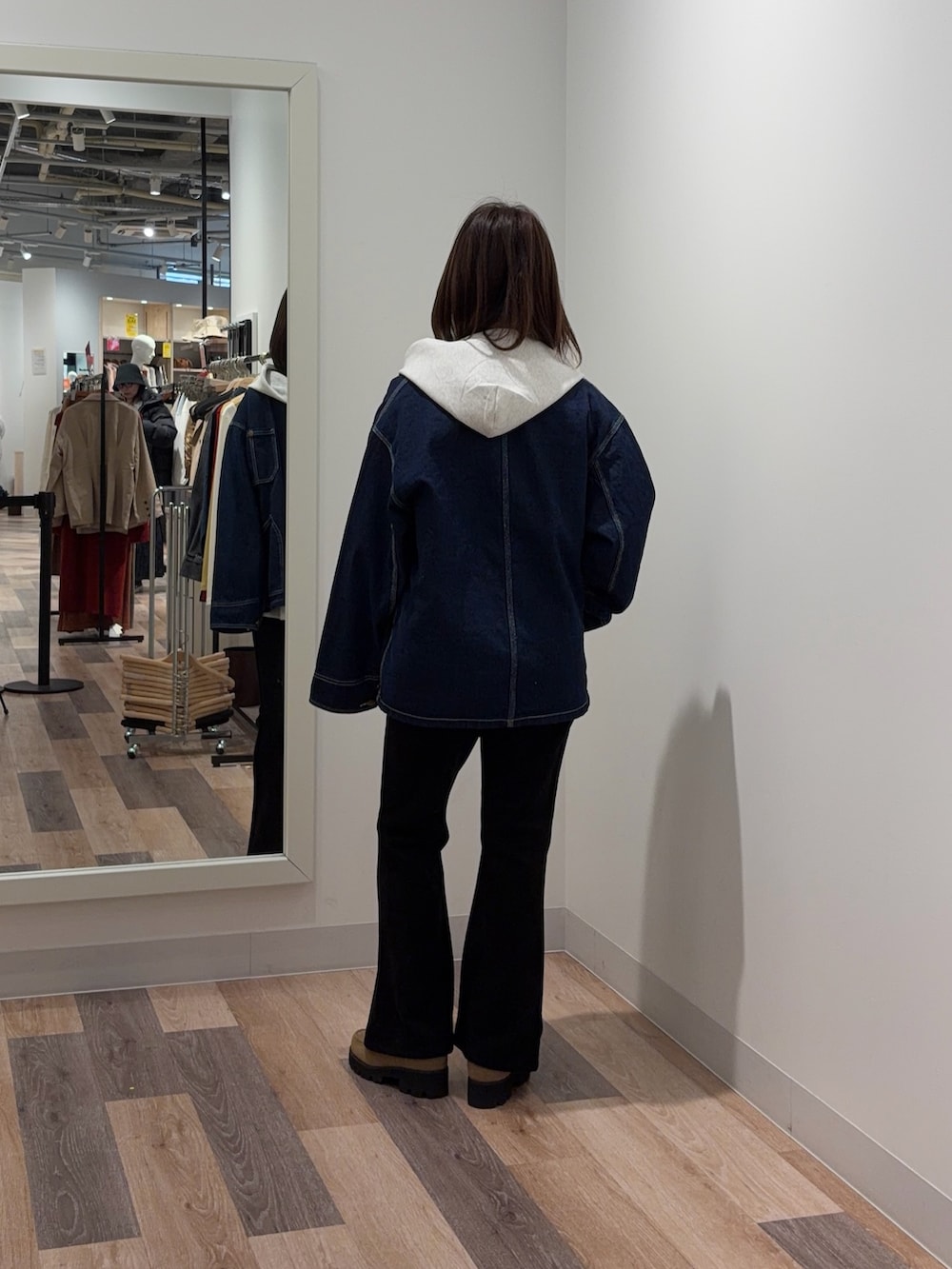 ブルー系のデニムジャケット、ホワイト系のパーカー、ブラック系のその他パンツを着用したレディースの冬コーディネートの3枚目の写真