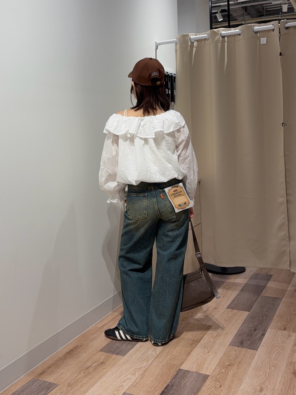 ホワイト系のシャツ/ブラウス、ブルー系のデニムパンツ、ブラウン系のトートバッグを着用したレディースの春コーディネートの3枚目の写真