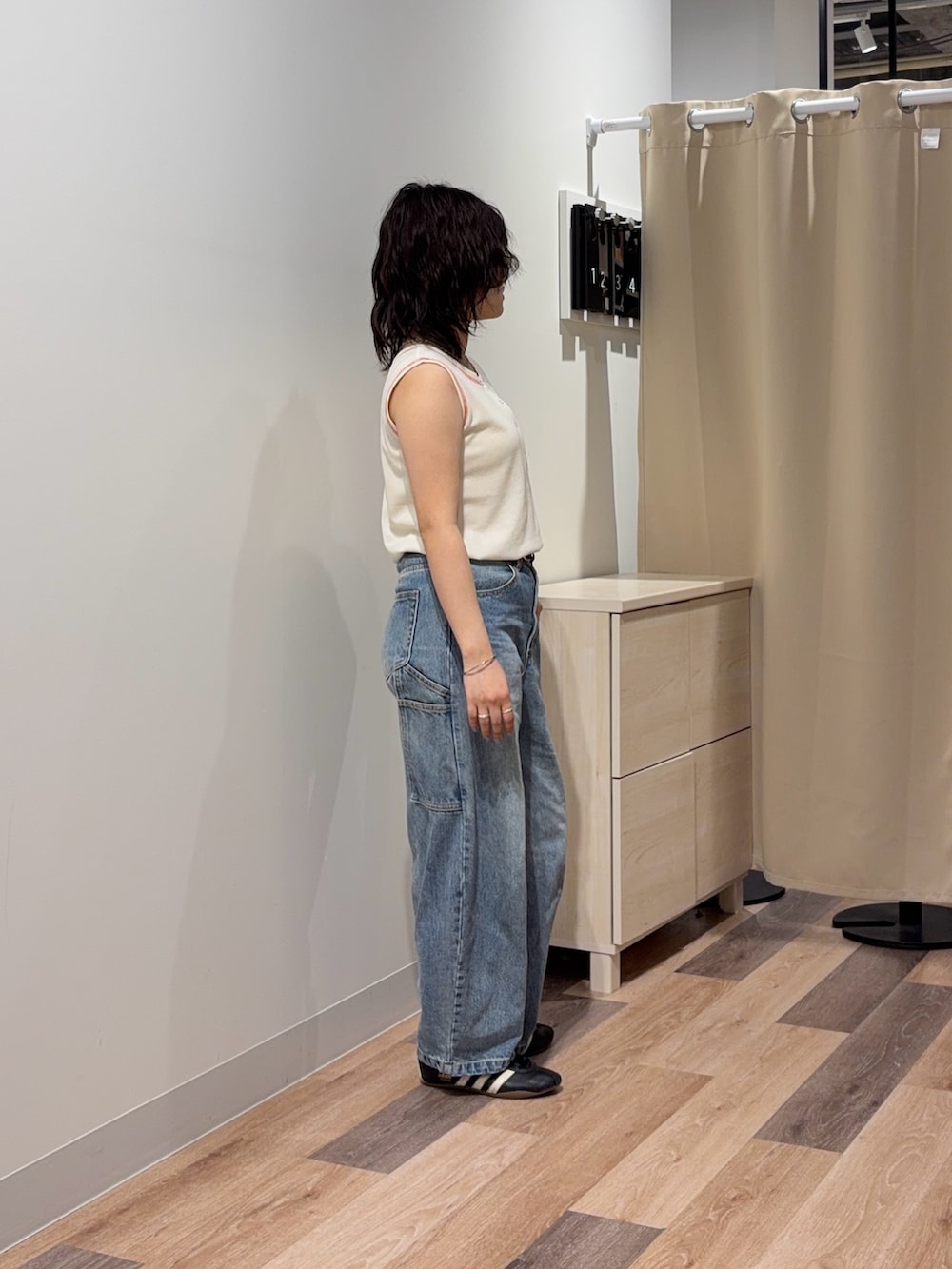 ホワイト系のキャミソール、ブルー系のデニムパンツを着用したレディースの春コーディネートの2枚目の写真